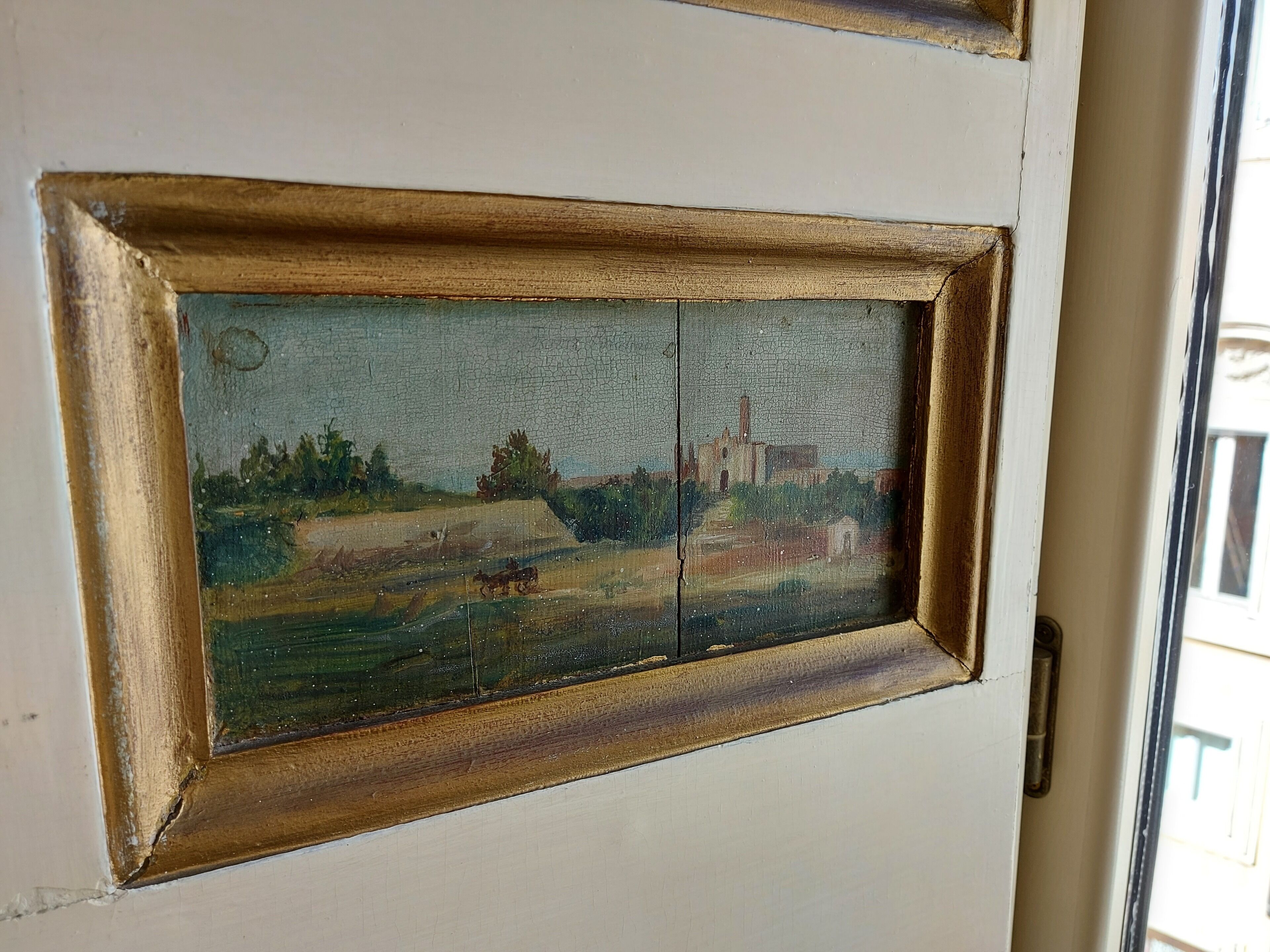 A door with a framed painting of a landscape.