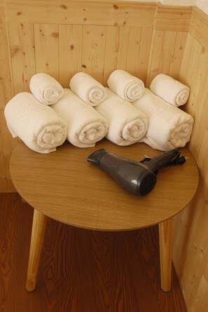 Regadera, secadora de cabello, pantuflas, jabón 
