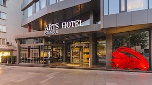 The exterior of the Arts Hotel in Istanbul, featuring a modern facade, large glass entrance, and a prominent red sculpture. - Arts Hotel Istanbul - Special Class (Istanbul)