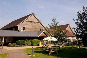 A wooden building with a sign that reads "The Inn at the Innkeeper's Lodge." - Sleep Inn Tewkesbury (Malmesbury)