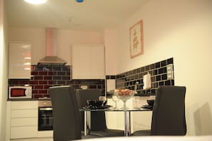 Uma cozinha moderna com área de refeições. Possui micro-ondas, forno e painel de backsplash em estilo preto e branco.