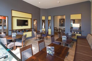 A modern hotel lobby with multiple seating areas, a flat-screen TV, and a reception desk. - Premier Inn Bournemouth Central (Bournemouth)