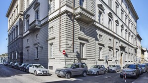 Un edificio grande e histórico con fachada simétrica, múltiples ventanas y una entrada destacada.