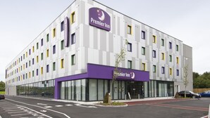 A Premier Inn hotel with a modern design, large windows, and a purple and white color scheme. - Premier Inn London Stansted Airport (Bishop's Stortford)
