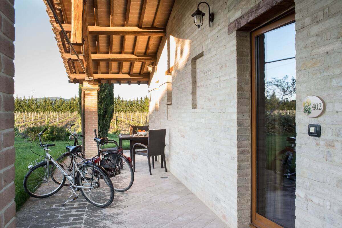 A covered patio with bicycles, a table, and chairs.