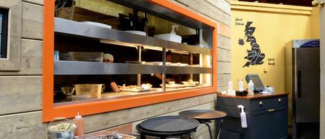 A restaurant with a wooden exterior, a window display with food items, and a map on the wall.