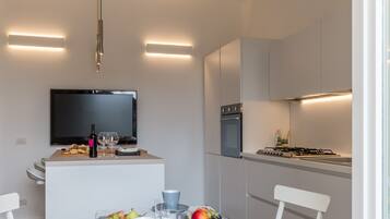 Una cocina moderna con comedor, televisor de pantalla plana y estufa a gas.