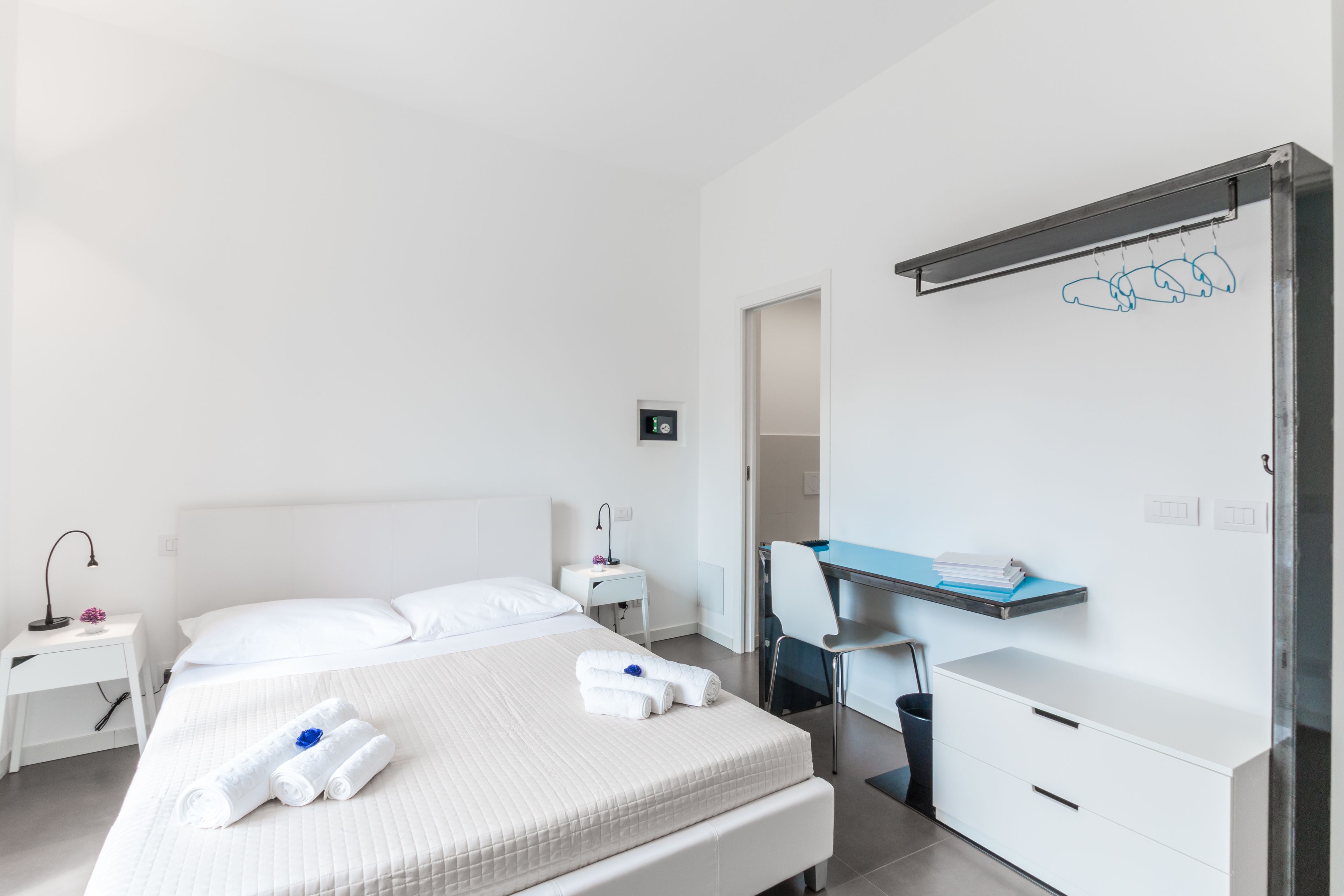 Una habitación de hotel moderna con una cama grande, un escritorio y una silla.
