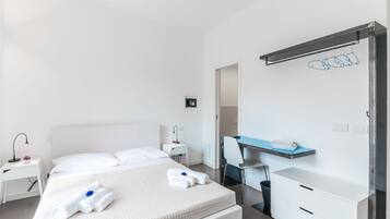 Una habitación de hotel moderna con una cama grande, un escritorio y una silla.