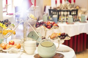 Une table de buffet avec divers fruits et une théière.