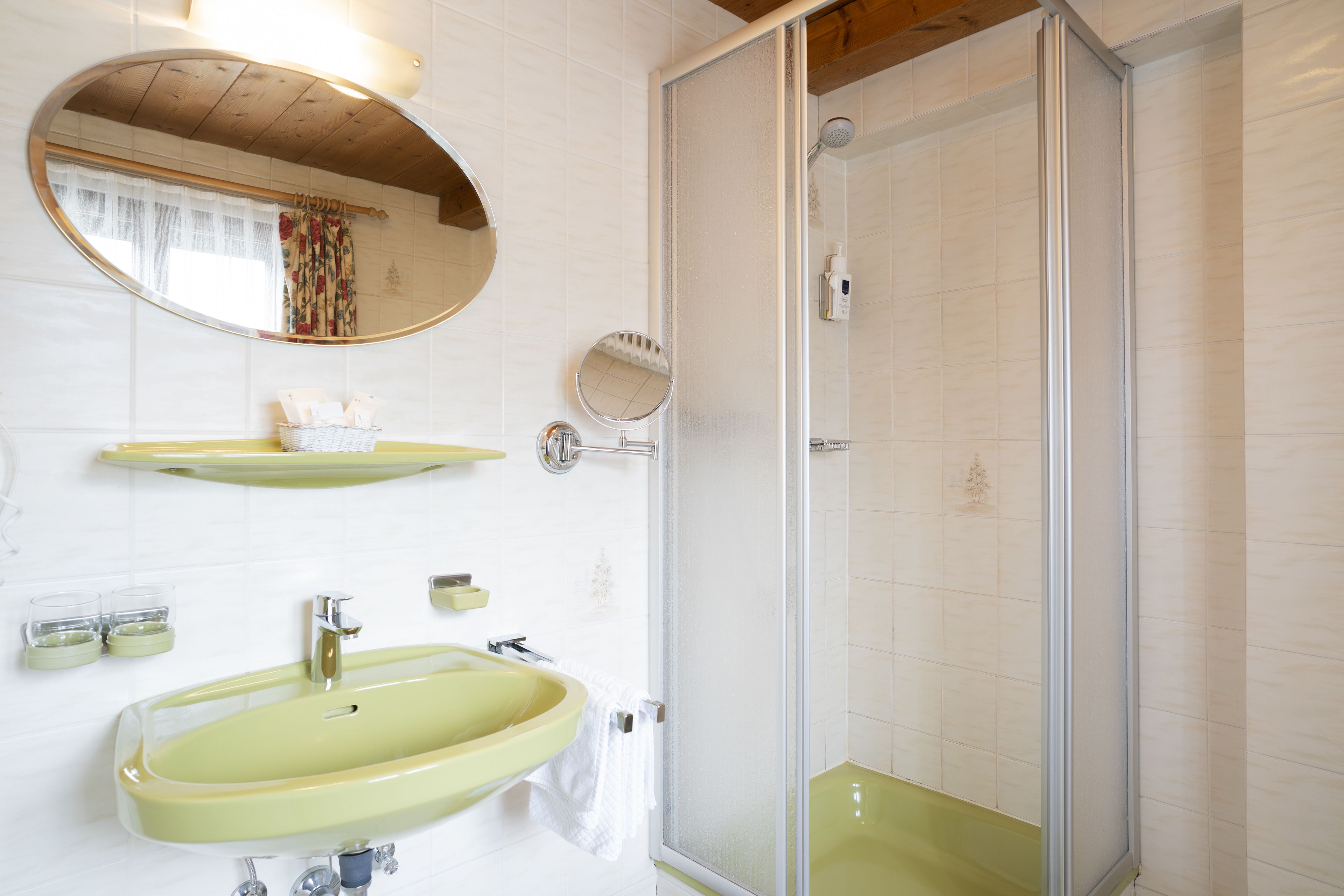 A bathroom with a yellow sink, a mirror, and a shower enclosure.
