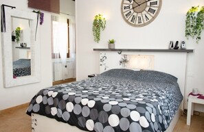 Une chambre à coucher avec un lit, une horloge murale ronde et une étagère avec des plantes.