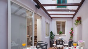Un comedor con una mesa dispuesta para dos, una ventana con vistas y una estructura de techo de madera.
