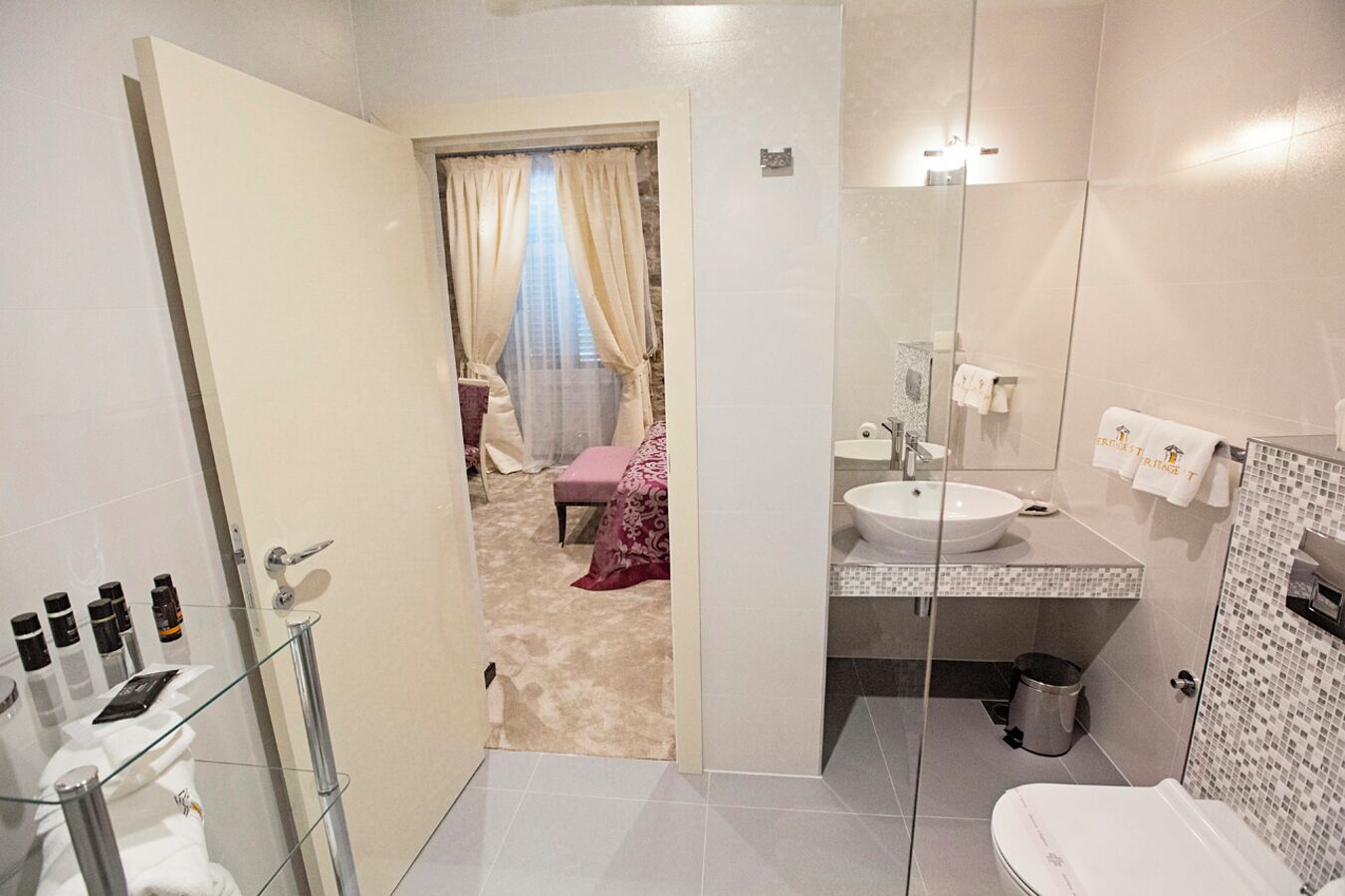 Une salle de bain moderne avec une douche à parois de verre, un lavabo avec un miroir et des toilettes.