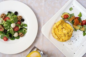 Zwei Teller Essen, einer mit Salat und der andere mit Rührei und Gemüse.