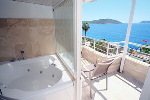 A balcony with a view of the sea, a bathtub, and a chair. - Nur Hotel (Kas)