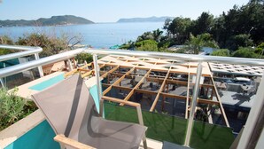 Terraço no terraço com piscina, área de estar externa e vista para o mar.