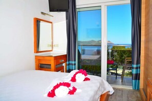 A hotel room with a bed, a wooden dresser, a mirror, and a balcony with a view. - Nur Hotel (Kas)