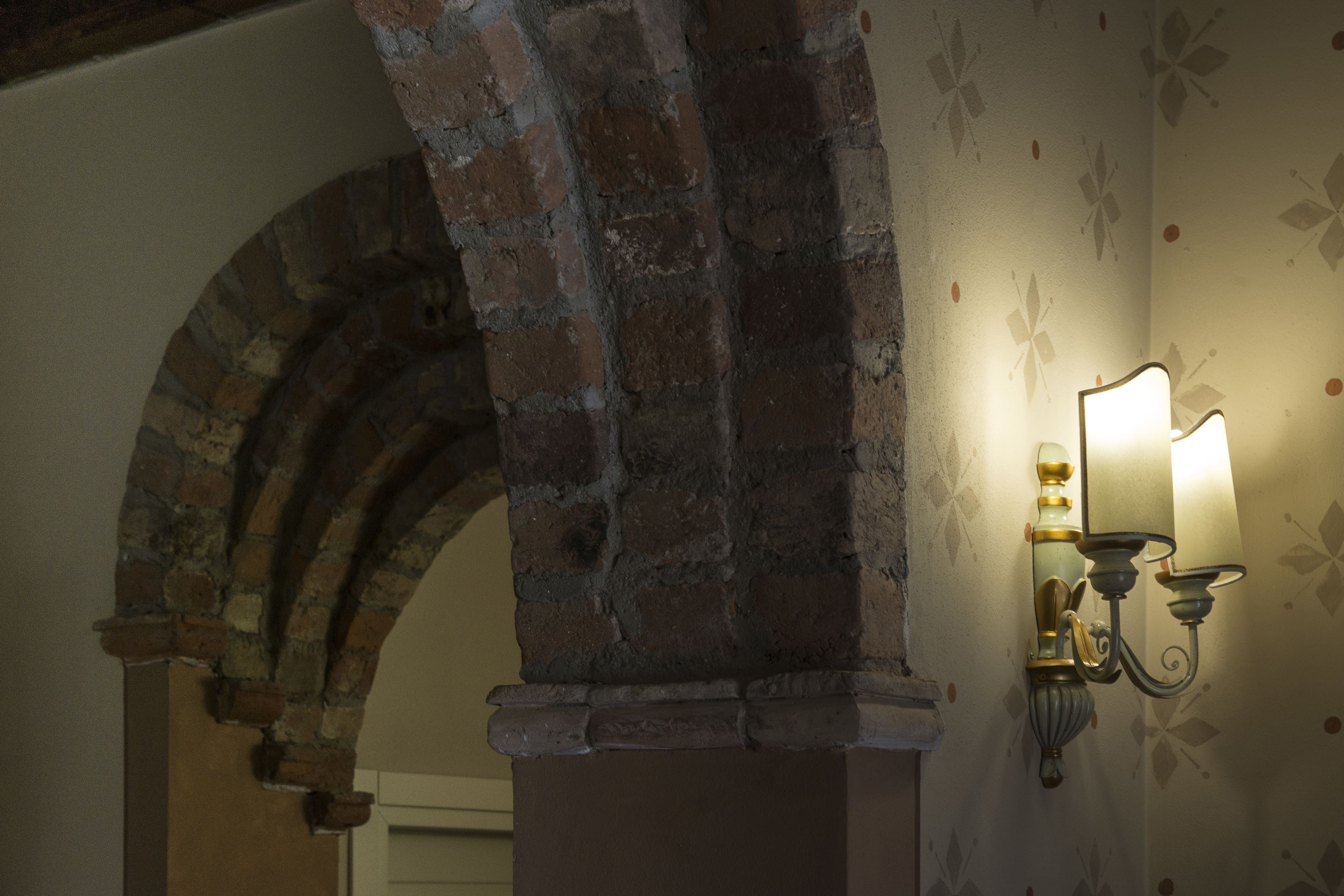 A stone archway and a wall-mounted light fixture.