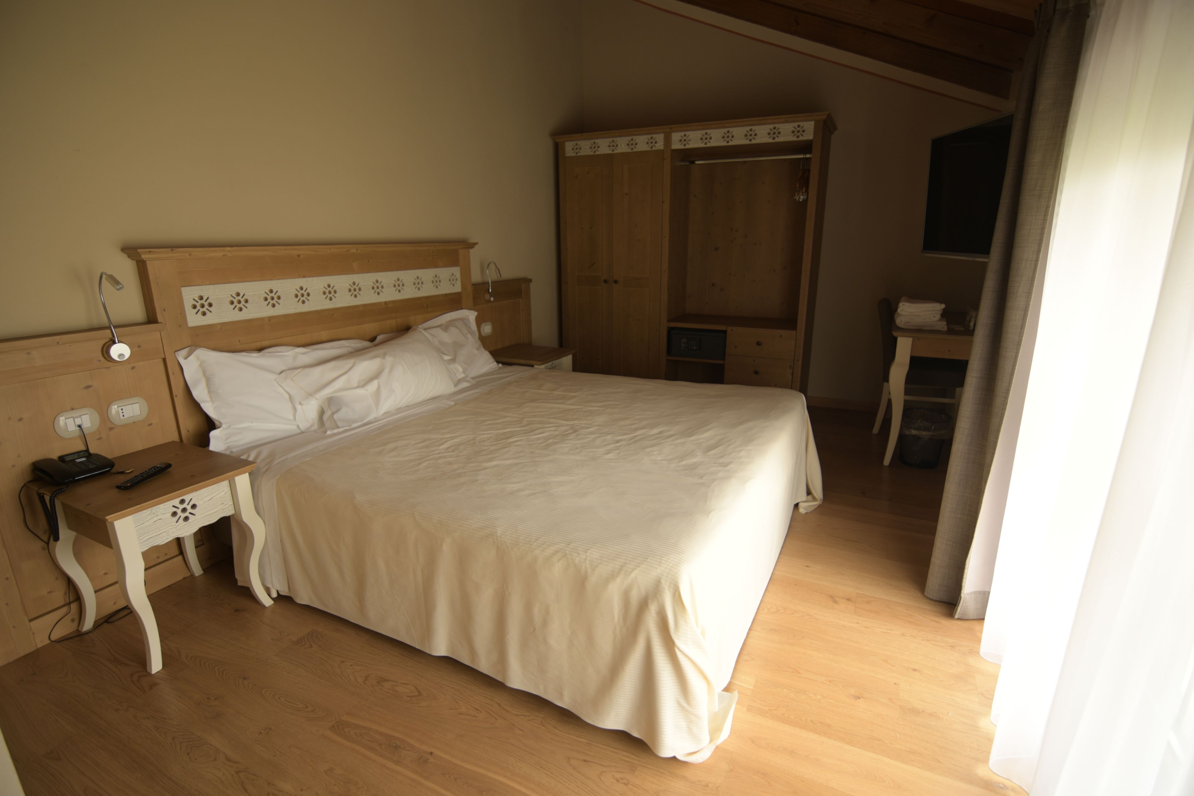 Un dormitorio con cama, mesita de noche de madera y armario.
