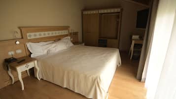 Un dormitorio con cama, mesita de noche de madera y armario.