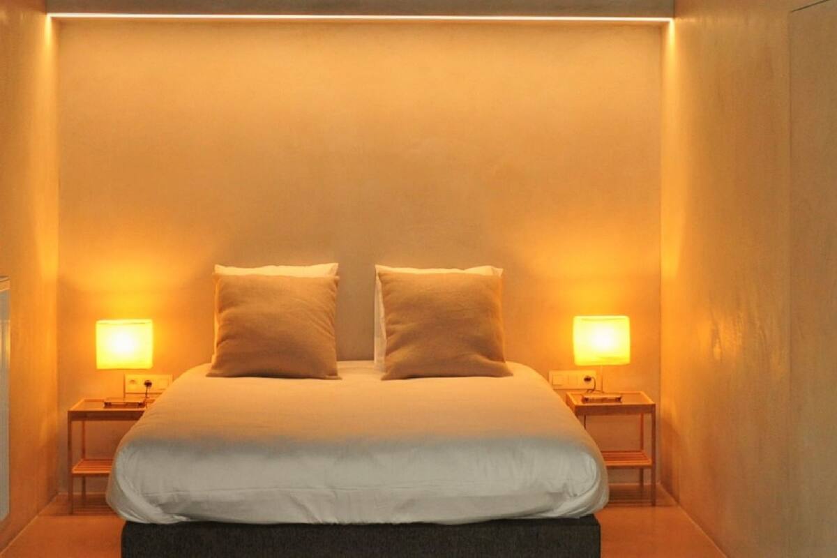 Une chambre d’hôtel avec un grand lit, deux lampes de chevet et une petite table.