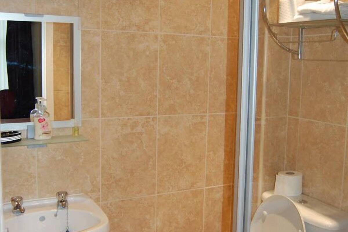 A bathroom with a sink, toilet, and a glass shower enclosure.