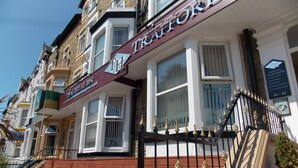 A row of terraced houses with a prominent sign for 'The Trafford' on the front. - The Trafford Hotel (Blackpool)