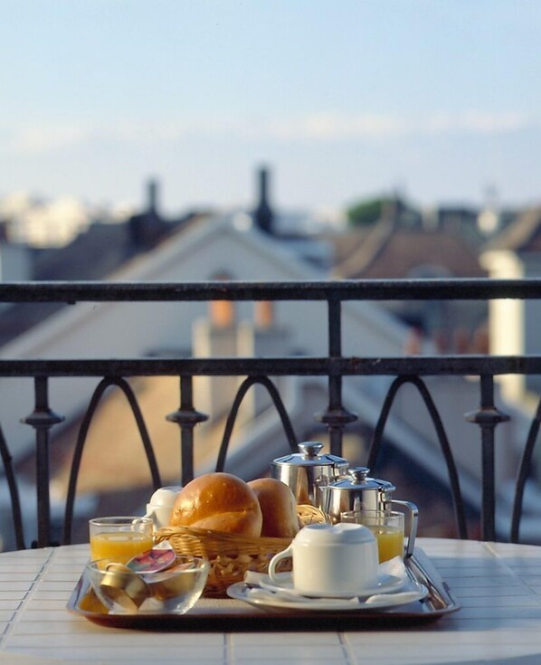 Una bandeja de desayuno en un balcón con vista a la ciudad.
