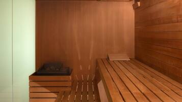 Eine Sauna mit Holzbänken und einer Bank mit schwarzem Sitzkissen.
