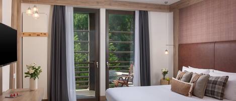 Un dormitorio moderno con una cama grande, un escritorio de madera y una televisión.