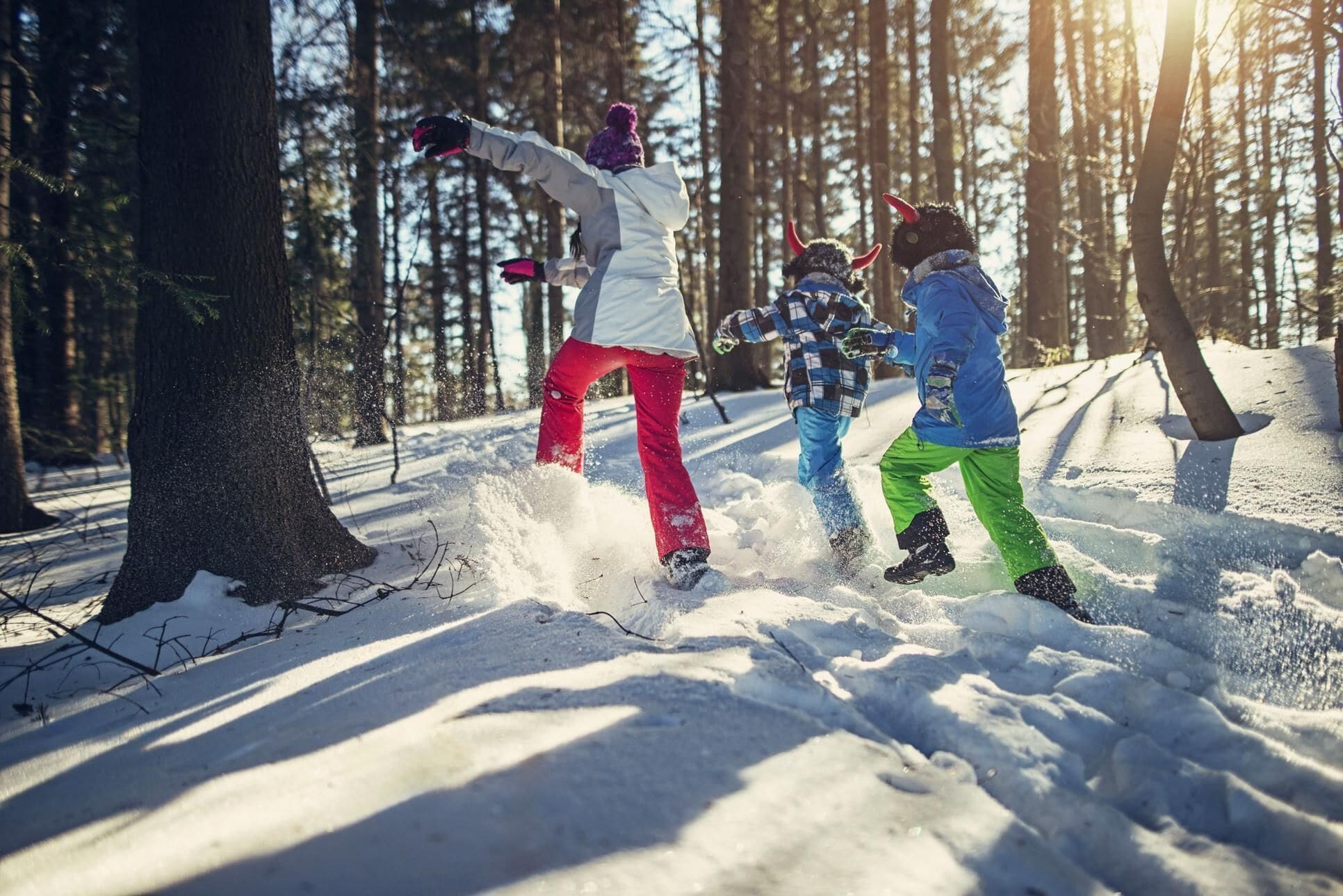 Three people playing in the snow.