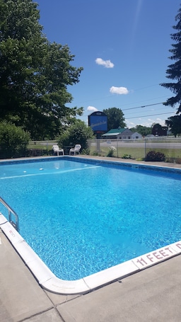 Una piscina al aire libre, sillones reclinables de piscina