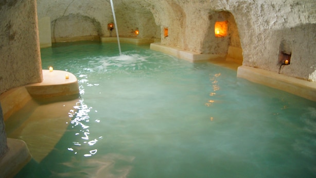 A cave-like interior with a pool and warm lighting.