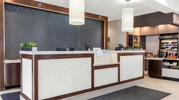 Una recepción con diseño moderno, una barra y una exhibición de botellas de agua.
