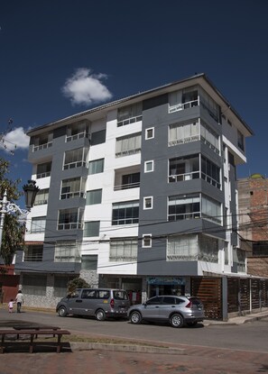 A multi-story building with a modern architectural design, featuring balconies and large windows. - Terra Nostra Suites (Cusco)