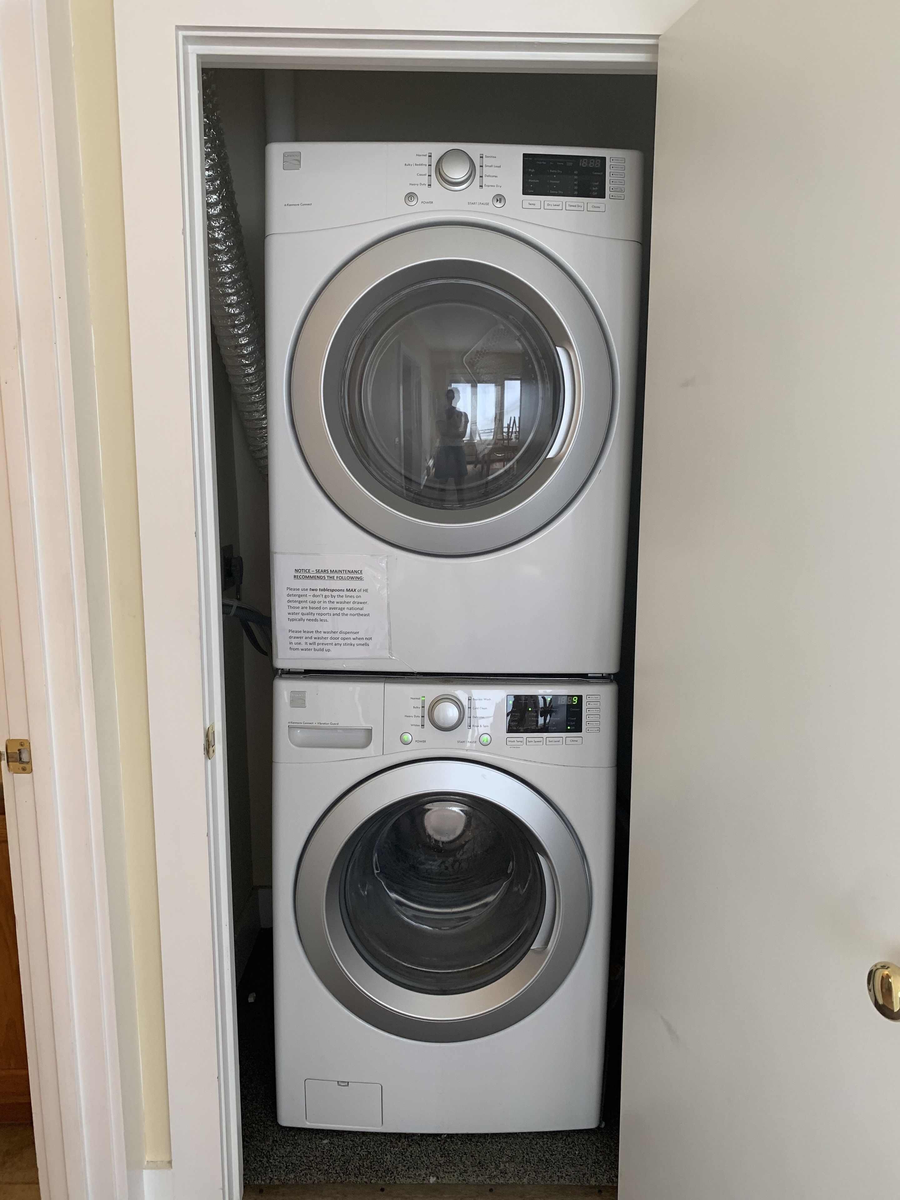 A compact, white stacked washer and dryer unit with a control panel and a digital display.