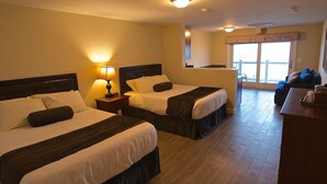 A hotel room with two beds, a desk, and a balcony with a view. - The Pelham Resort Motel (Hampton)