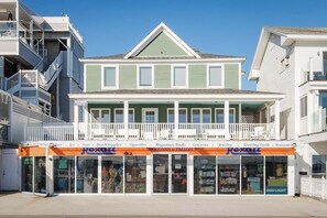 A beachfront building with a balcony, storefronts, and a clear sky. - The Pelham Resort Motel (Hampton)