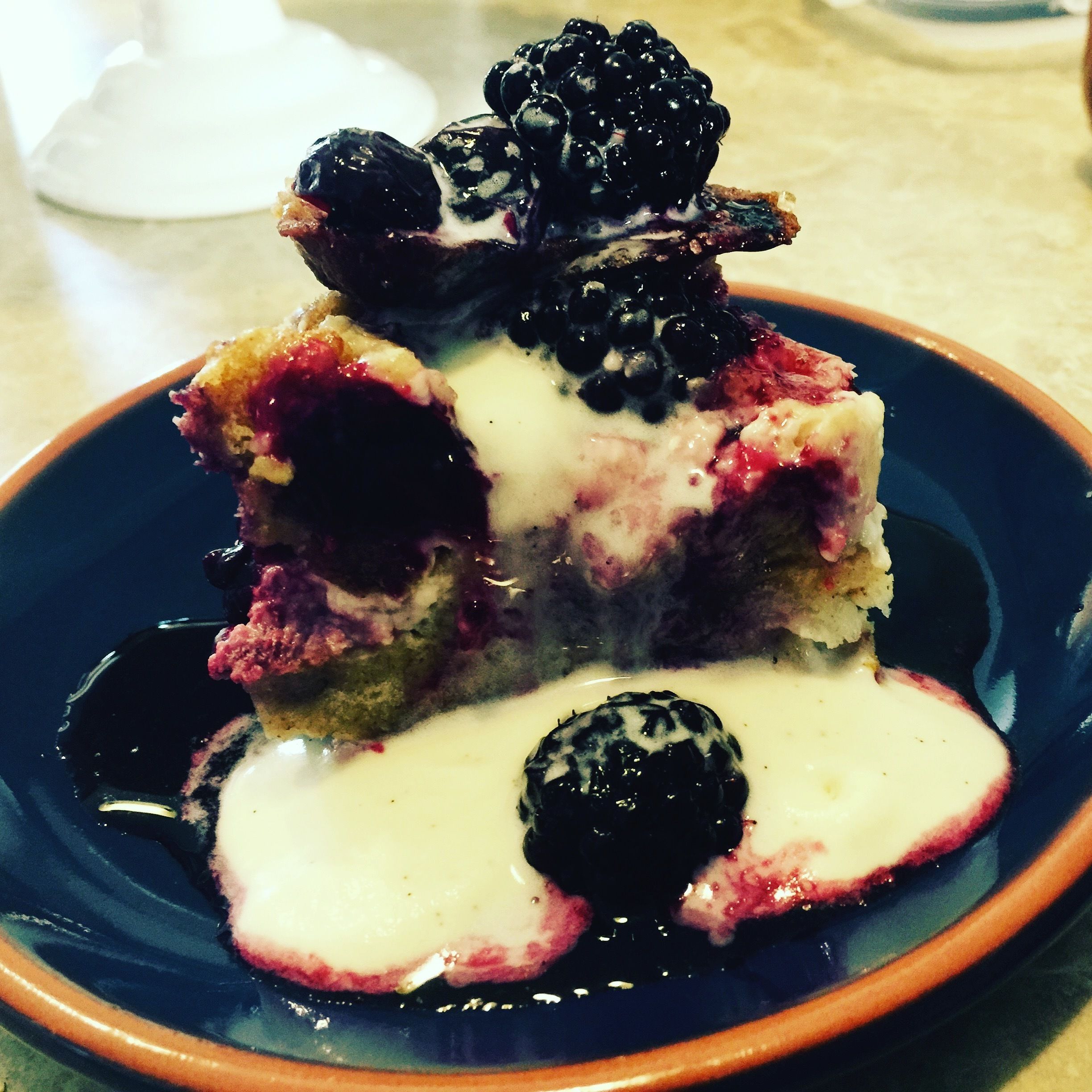 Una porción de pastel con bayas y crema en un plato.