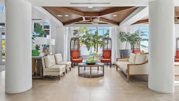 A spacious lobby with a high ceiling, a central round table, and seating arrangements.