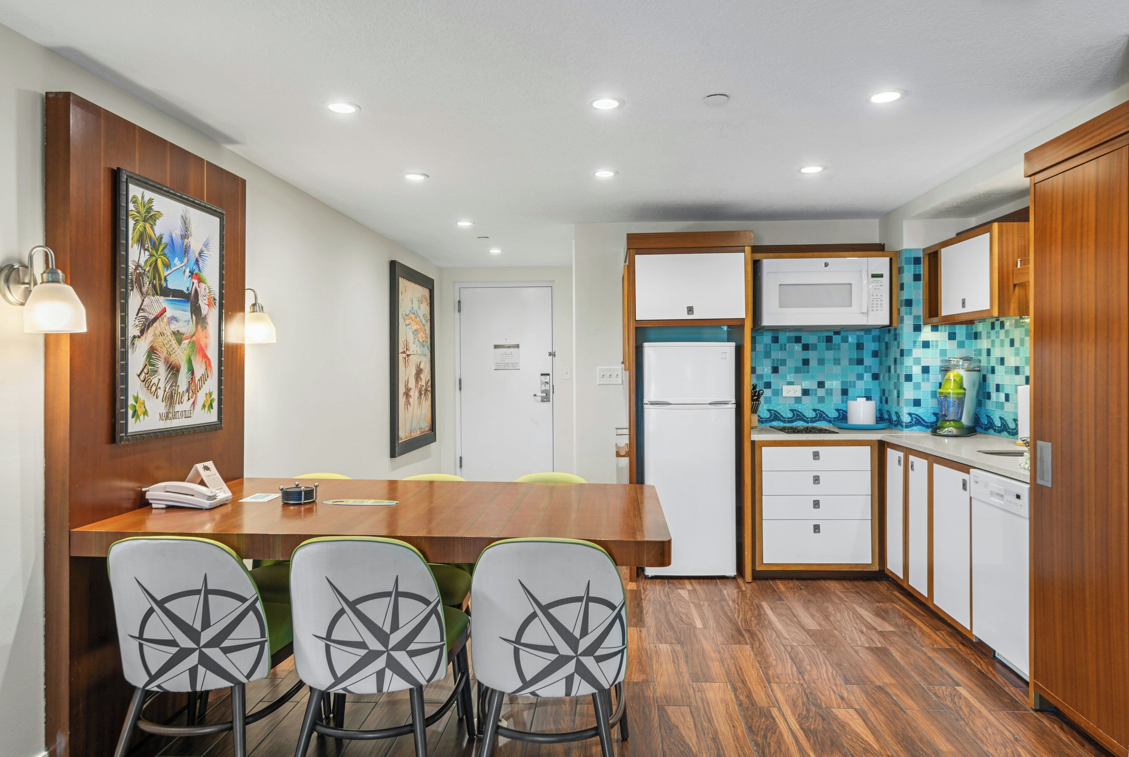 Una cocina moderna con armarios de madera, una mesa de comedor con sillas y un salpicadero de azulejos.