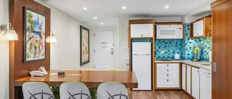A modern kitchen with wooden cabinets, a dining table with chairs, and a tiled backsplash.