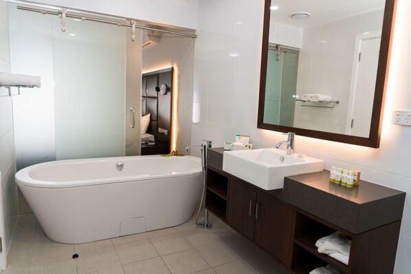 Une salle de bain moderne avec une baignoire sur pieds, un meuble-lavabo avec un miroir et un espace douche.