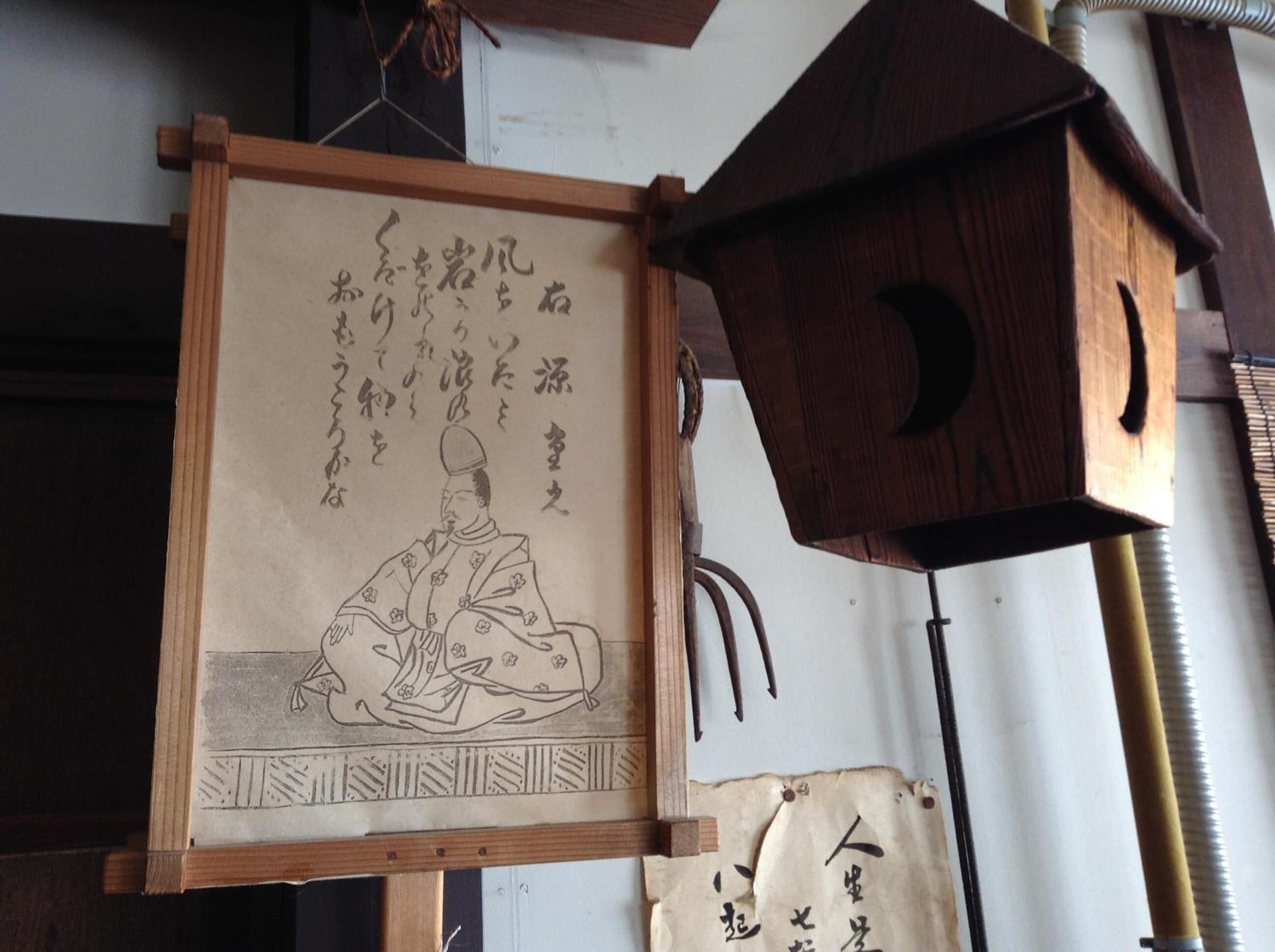 A traditional Japanese room with tatami flooring, a shoji screen, and a wooden calligraphy scroll.
