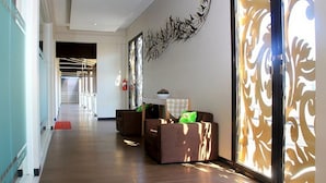 Un couloir doté d’un plancher en bois, d’un extincteur et d’un élément décoratif mural.