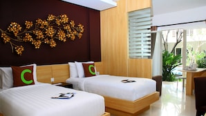 Une chambre d’hôtel moderne avec deux lits, une tête de lit en bois, un élément décoratif mural et une vue sur l’extérieur.
