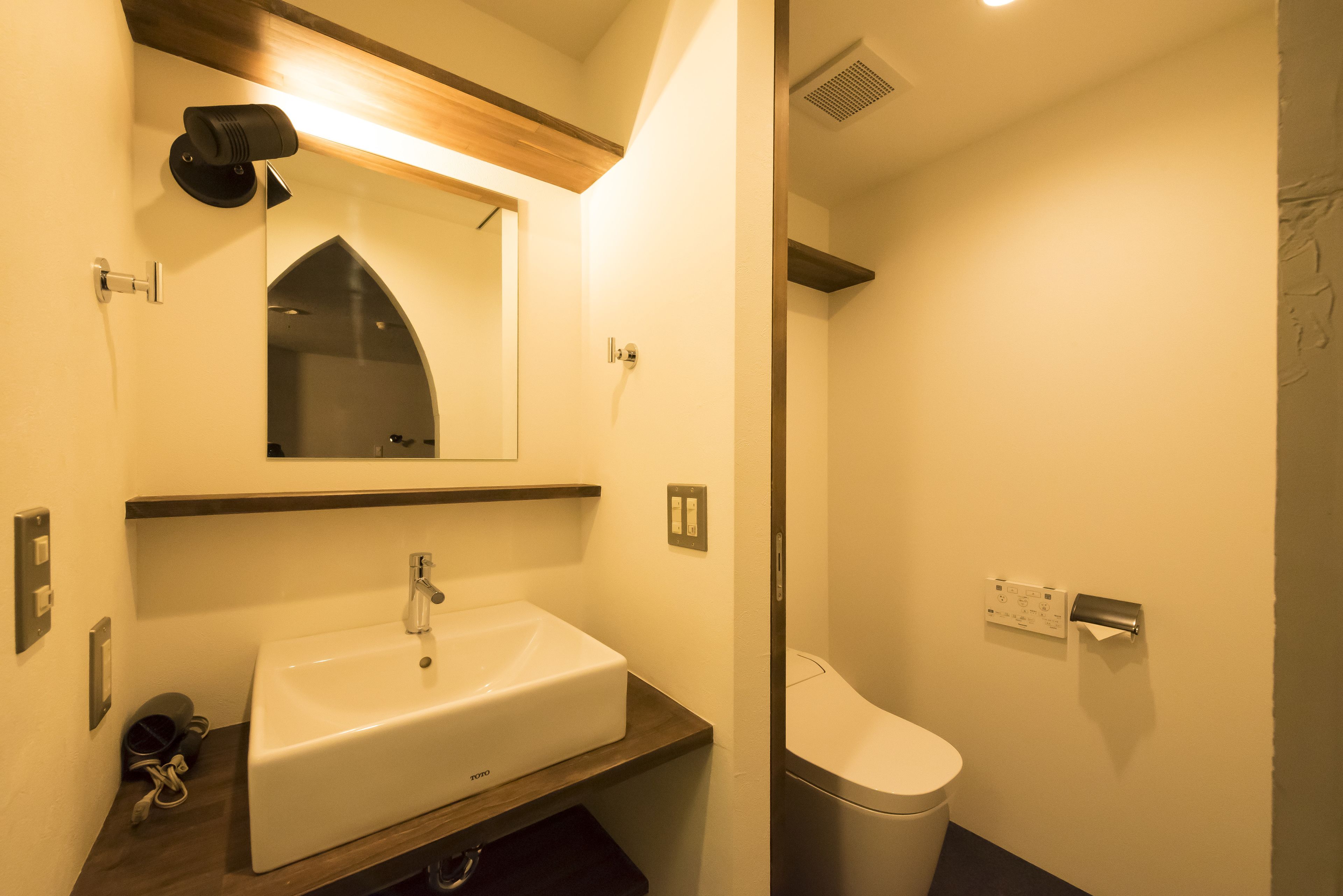 A bathroom with a white sink, a mirror, a towel rack, and a toilet.