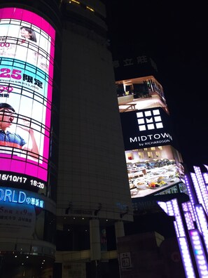 Un edificio con letreros iluminados, incluyendo uno que dice 'MIDTOWN by RICHARDSON' y otro que dice 'WORLD 中華新館'.