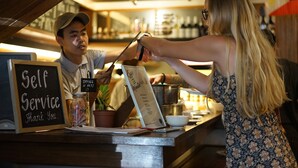 Un comptoir en libre-service avec un tableau affichant le menu et une pancarte indiquant : « Merci d’utiliser le service en libre-service. »